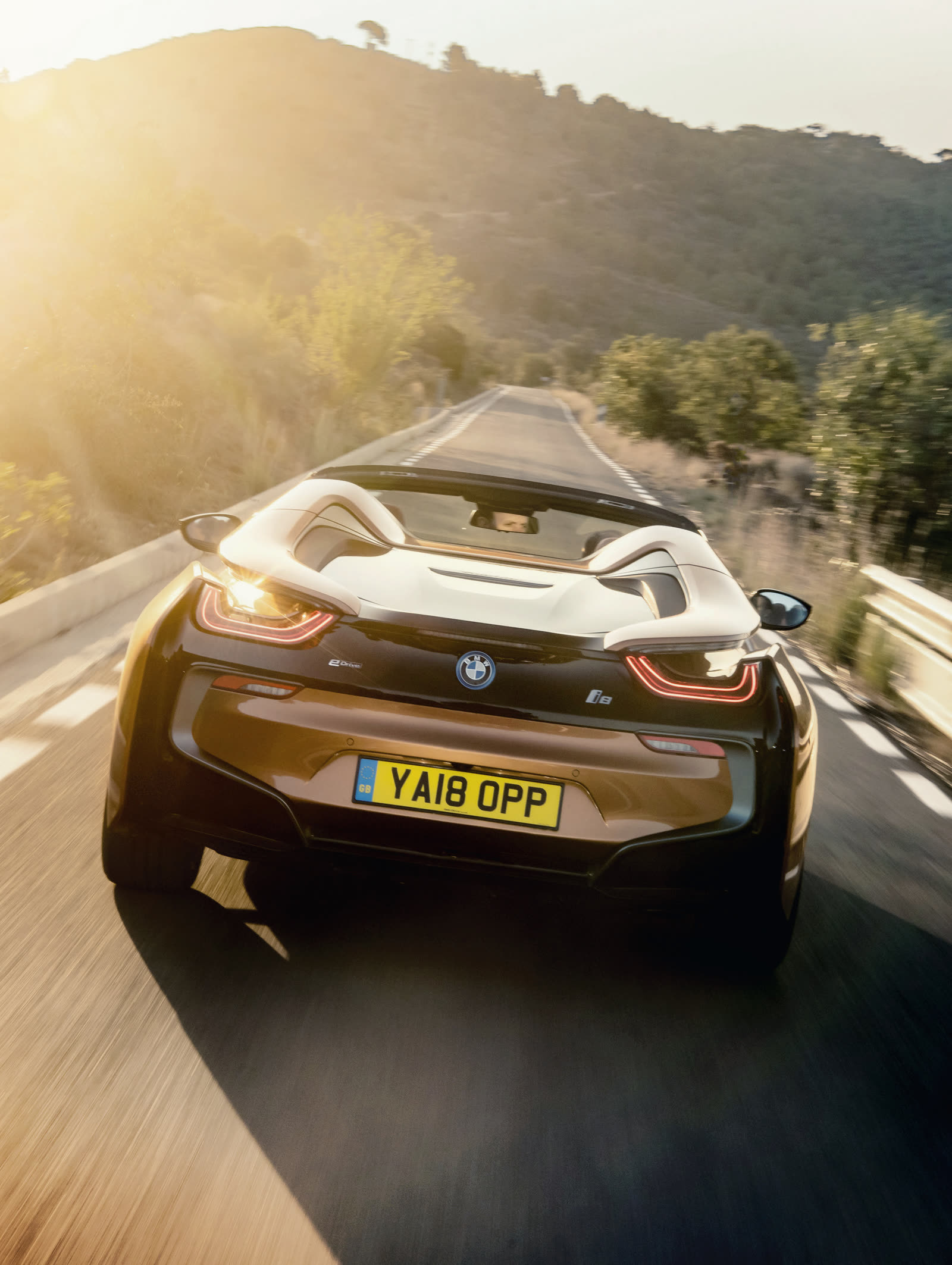 BMW i8 Roadster von hinten auf einer sonnigen Küstenstraße