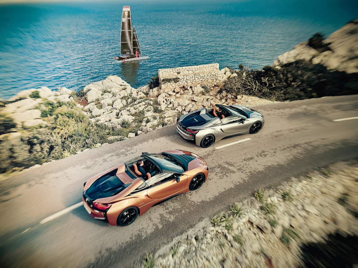 Zwei i8 Roadster auf der Küstenstraße über türkisem Meer