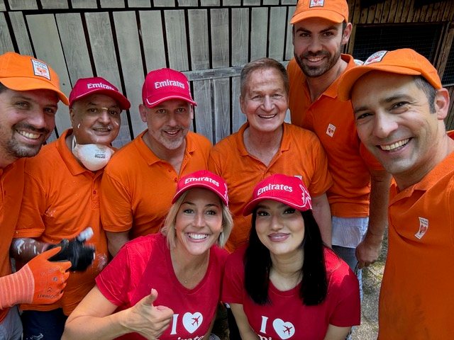 Team in orangefarbenen Sixt-Shirts bei einer Hilfsaktion