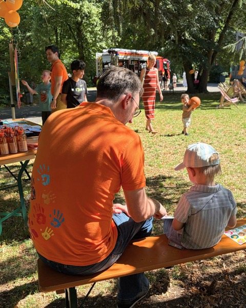 Helfer spielt mit Kindern im Freien