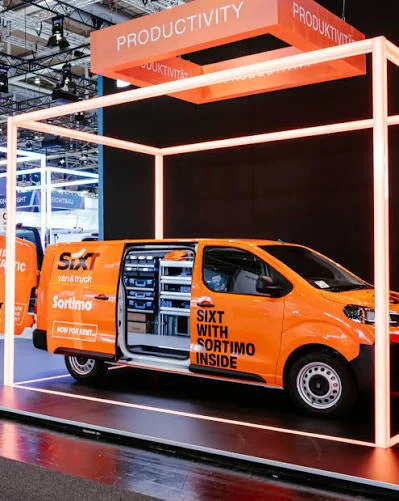Oranger Sixt-Transporter mit der Aufschrift „Sixt with Sortimo inside“