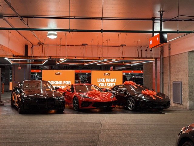 Oranger Sixt-Showroom mit Sportwagen und der Frage „Like what you see?“
