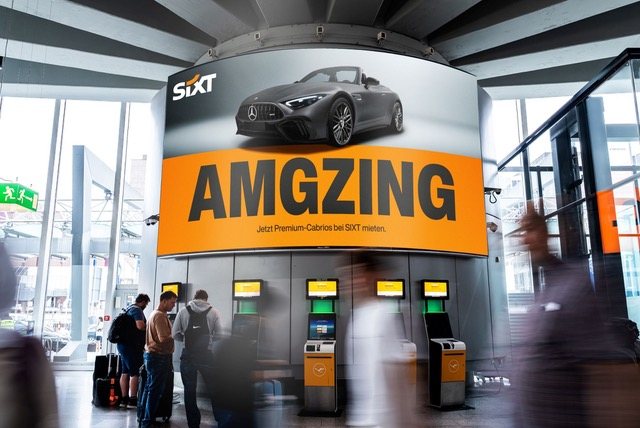Sixt-Station im Flughafen mit dem Kampagnenmotiv „AMGZING“