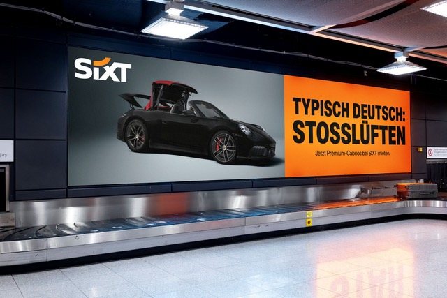 Gepäckband mit Sixt-Werbung „Typisch deutsch: Stoßlüften“